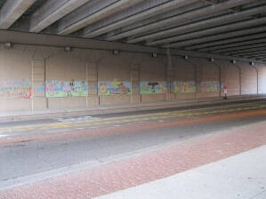 Mural under a highway overpass created by children with chalk.